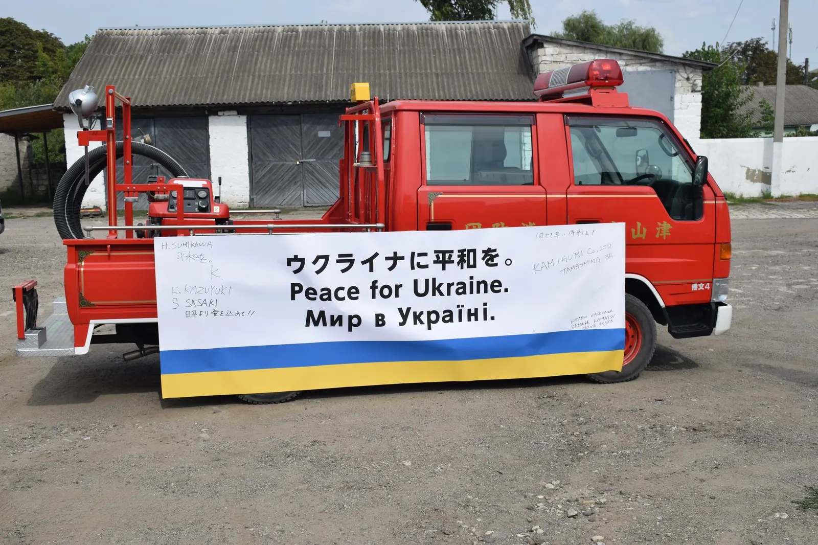 「ウクライナに平和を」の横断幕を掲げた、津山市消防団の文字が残る消防車